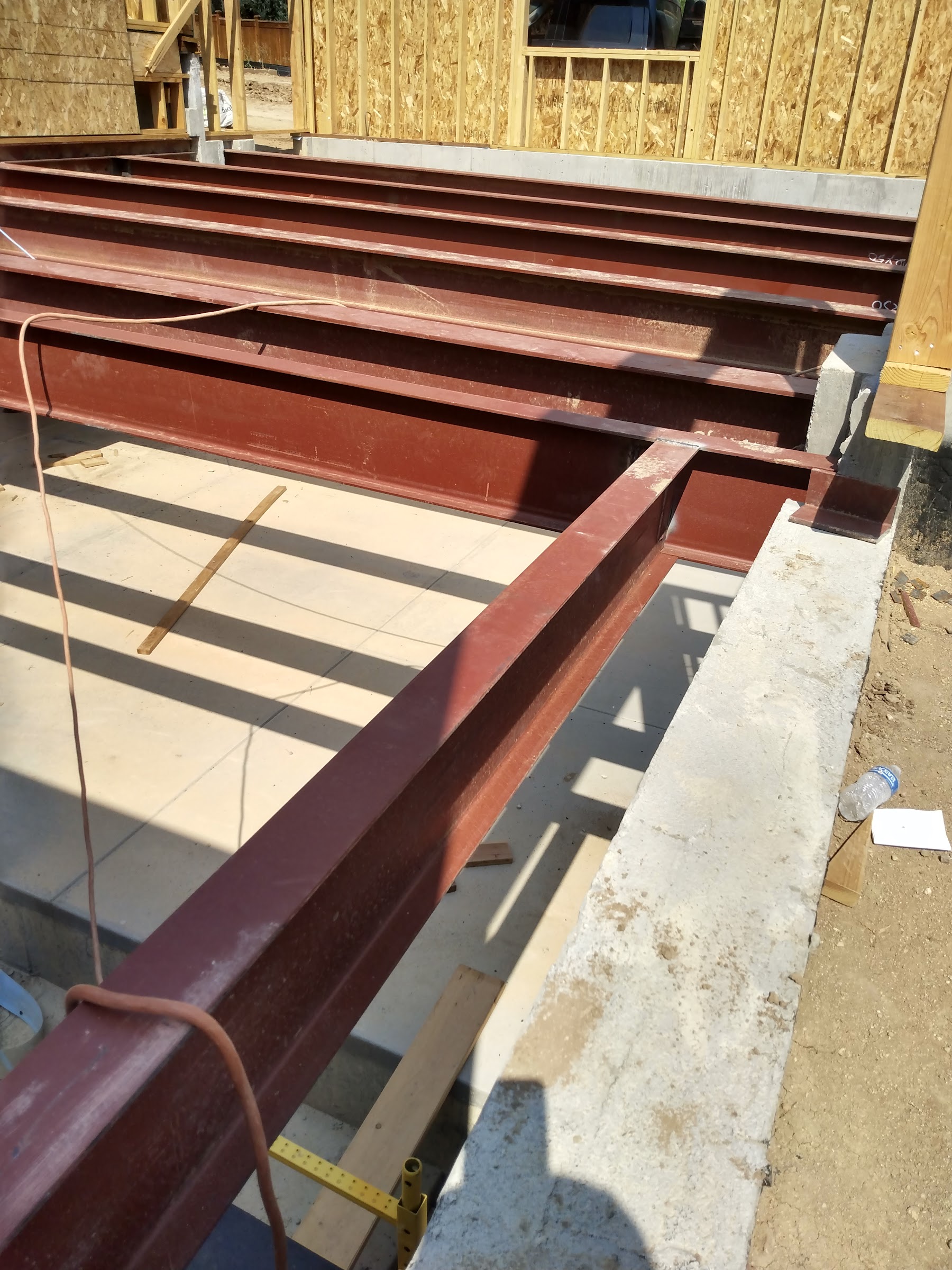 Structural steel I-beams welded and set on a residential foundation