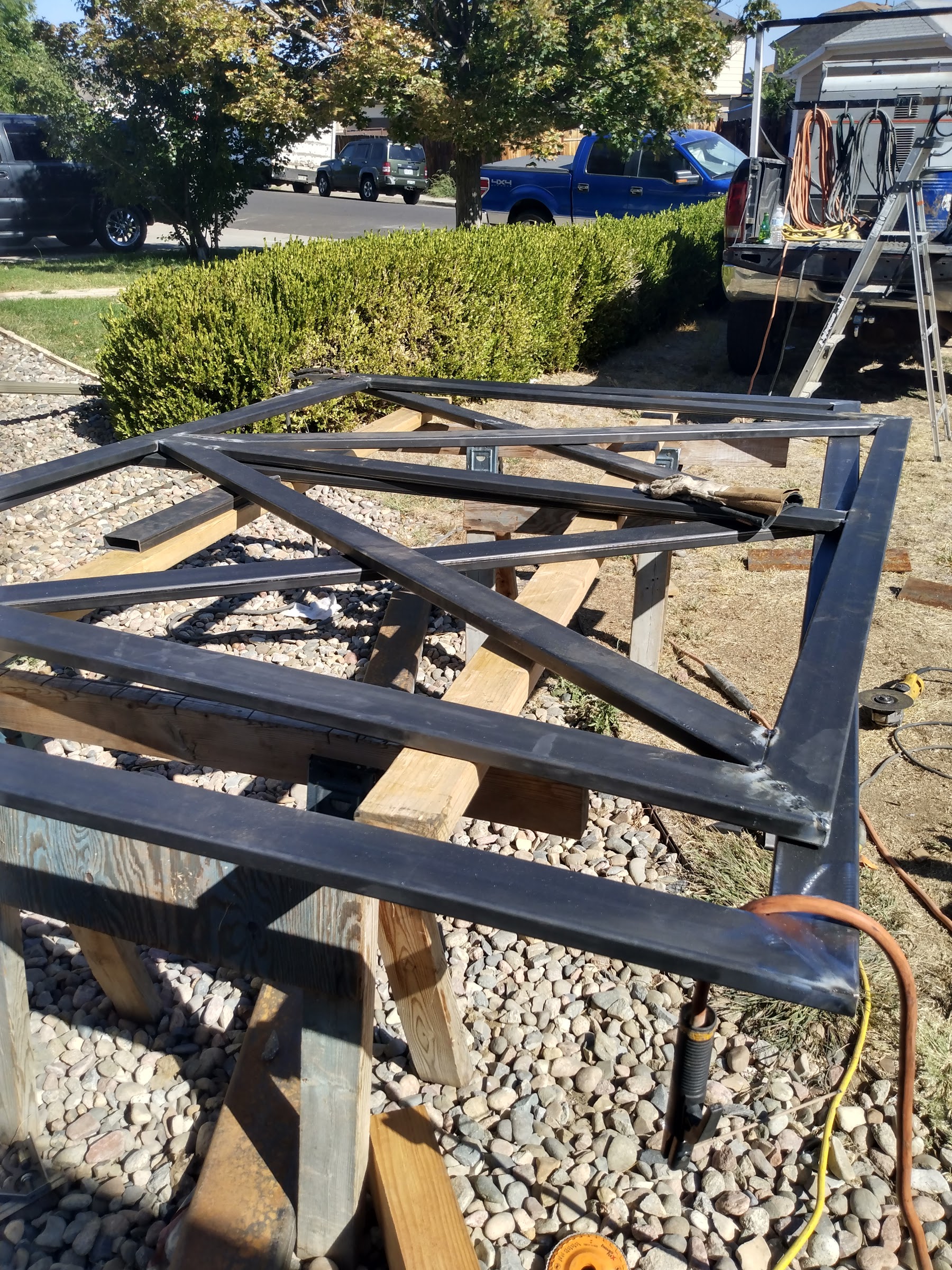 Custom cross-braced steel gate frame fabricated on sawhorses at a job site